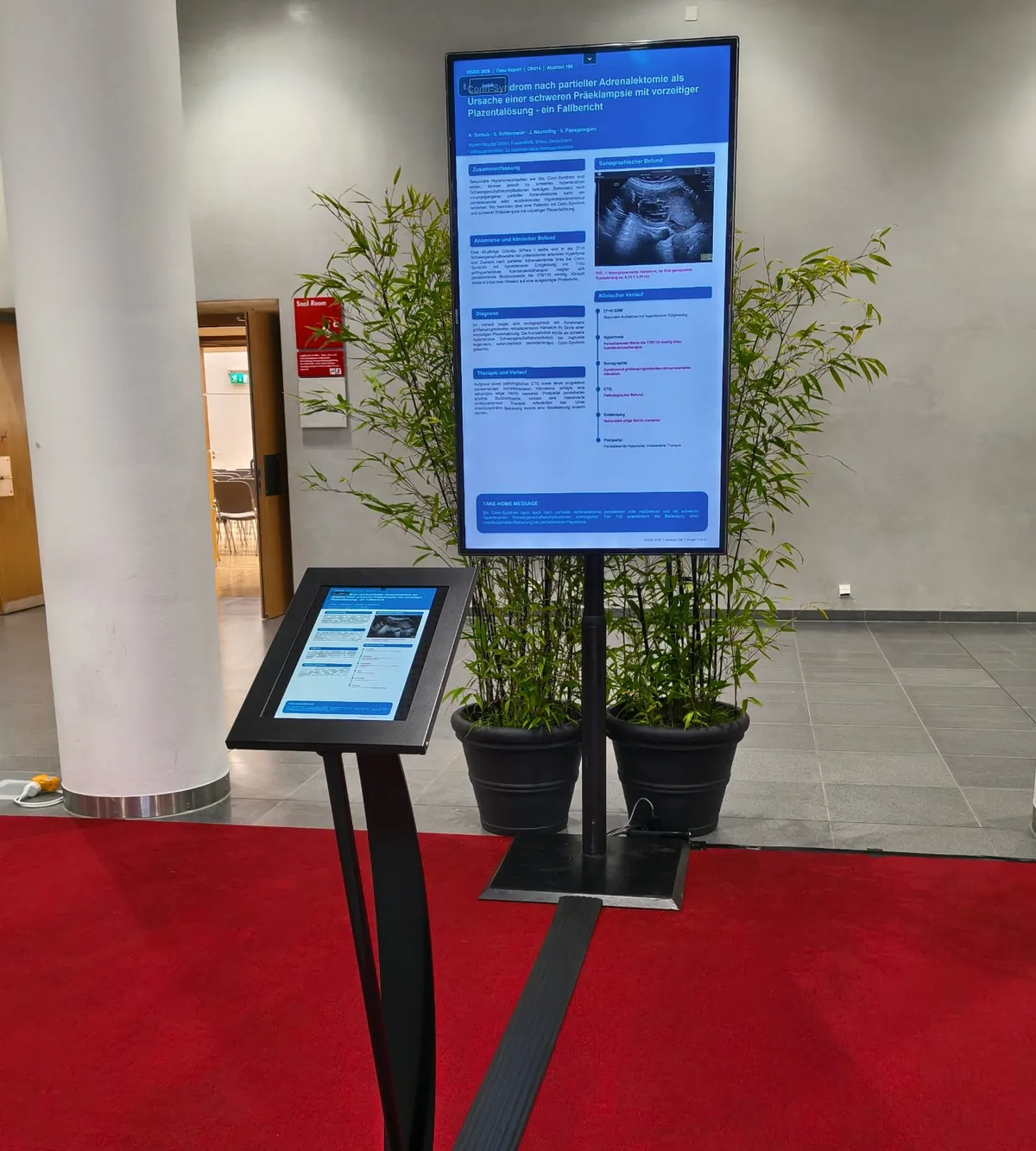 ePoster-Station auf einem Kongress: wissenschaftliches Poster auf großem Bildschirm, davor ein Tablet zur Steuerung
